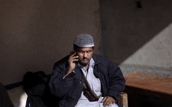A Pakistani militant looks on while talking on a mobile phone at their headquarters in Peshawar, Pakistan. Tribal militias allied with the government helped block a Taliban advance in this corner of northwest Pakistan close to the Afghan border, but their success has come at a price: the empowerment of untrained, unaccountable private armies that could yet emerge as a threat of their own.
